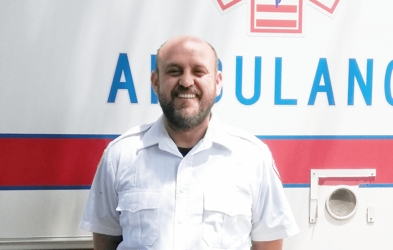 James Certain pictured standing in front of an ambulance