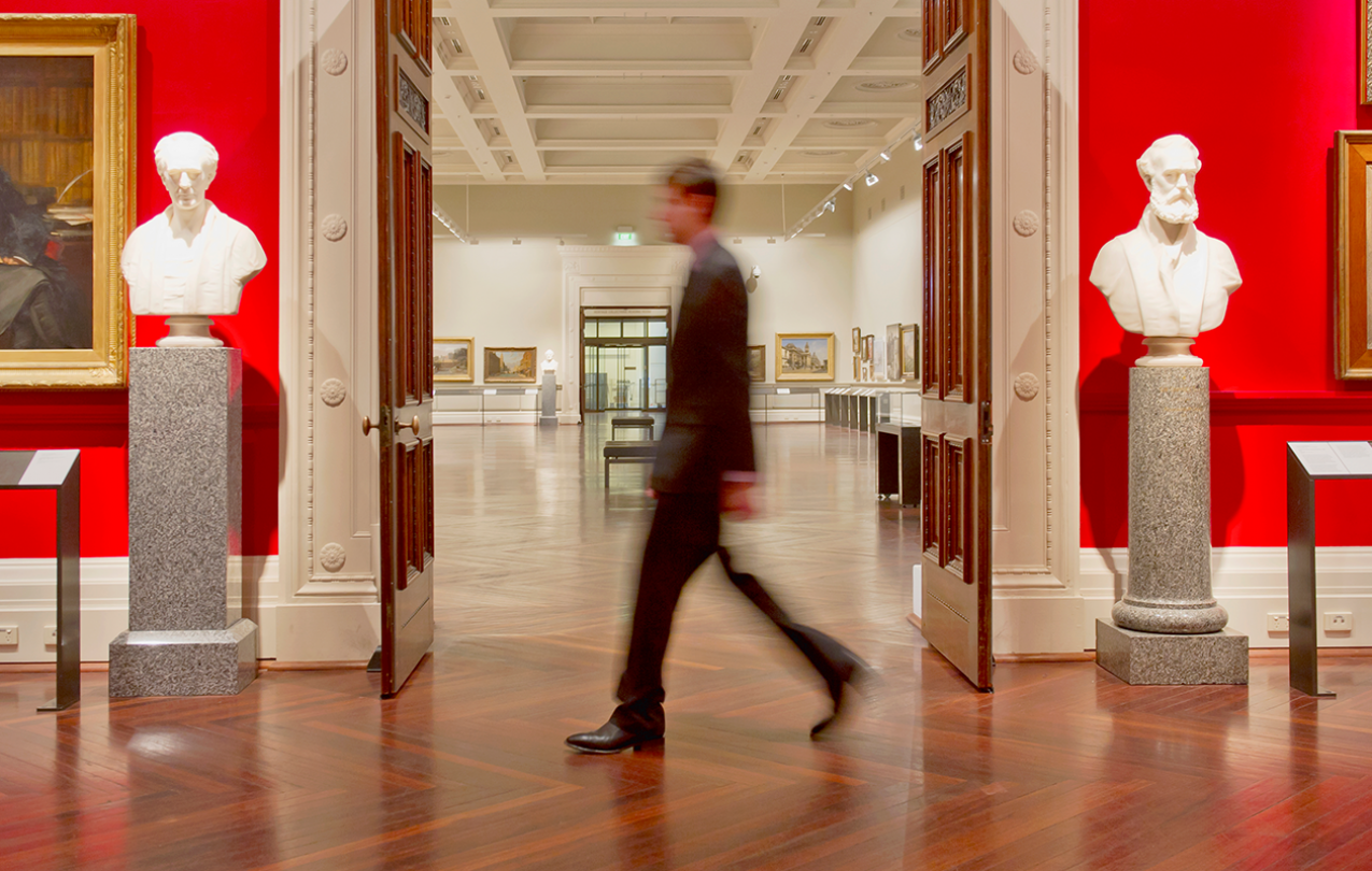 Photo of a man walking through a museum exhibit.