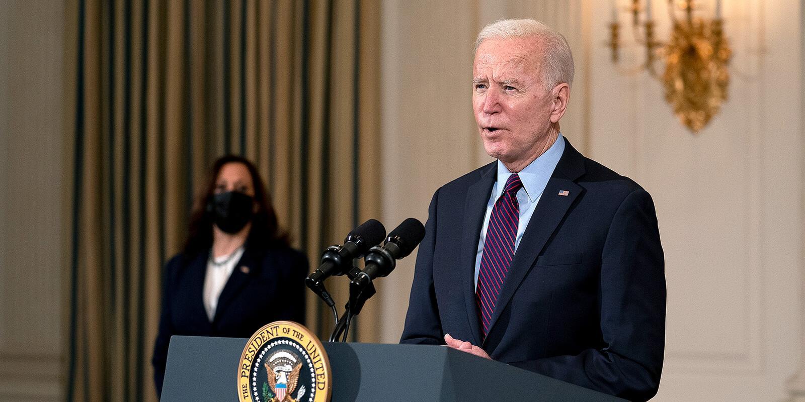 Biden speaking at podium and Karris behind him